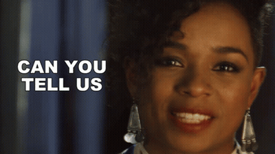 A Close Up Of A Woman 'S Face With The Words Can You Tell Us Behind Her GIF
