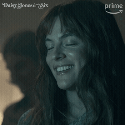 A Close Up Of A Woman 'S Face With The Words Daisy Jones & The Six On The Bottom GIF