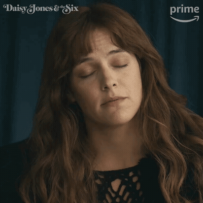 A Close Up Of A Woman 'S Face With The Words Daisy Jones & The Six On The Bottom GIF