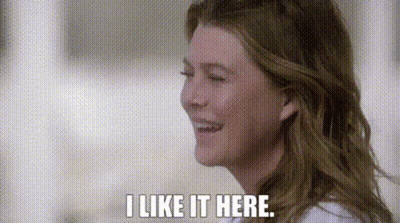 A Close Up Of A Woman 'S Face With The Words `` I Like It Here '' Written On It . GIF