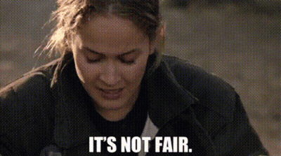 A Close Up Of A Woman 'S Face With The Words `` It 'S Not Fair '' Written Below Her . GIF