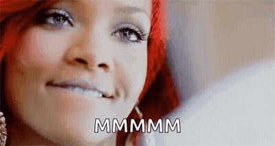 A Close Up Of A Woman 'S Face With The Words `` Mmmmm '' Written On The Bottom . GIF