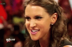 A Close Up Of A Woman 'S Face With The Words Wwe Live In The Background . GIF
