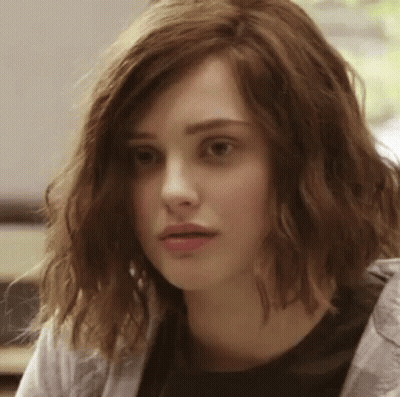 A Close Up Of A Woman 'S Face With Wavy Hair And A Black Shirt . GIF