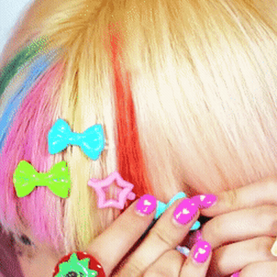 A Close Up Of A Woman 'S Hair With Colorful Hair Clips GIF