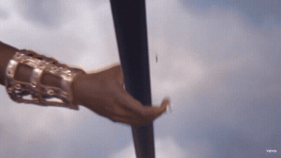 A Close Up Of A Woman 'S Hand Holding A Pole With A Blue Sky In The Background GIF