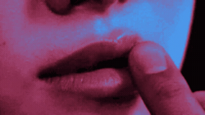 A Close Up Of A Woman 'S Lips With A Finger On Her Lips GIF