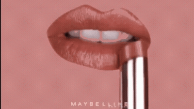 A Close Up Of A Woman 'S Lips With A Maybelline Lipstick Sticking Out Of Them . GIF