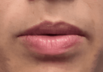 A Close Up Of A Woman 'S Lips With Pink Lipstick And Teeth . GIF