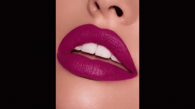 A Close Up Of A Woman 'S Lips With Purple Lipstick And The Words Kisses Below GIF