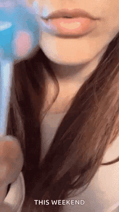 A Close Up Of A Woman 'S Lips With The Words `` This Weekend '' Written Above Her . GIF