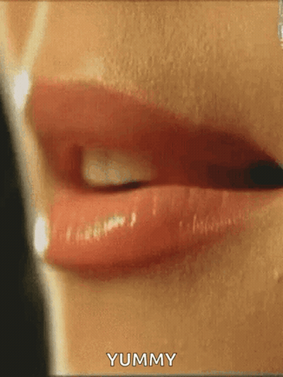 A Close Up Of A Woman 'S Lips With The Words Yummy Written On The Bottom . GIF