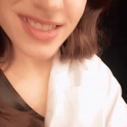 A Close Up Of A Woman 'S Mouth With A Piercing In It GIF
