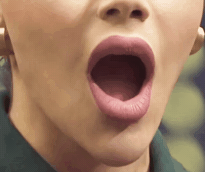 A Close Up Of A Woman 'S Mouth With Her Mouth Open And Her Tongue Sticking Out . GIF