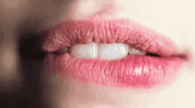 A Close Up Of A Woman 'S Mouth With Pink Lips And White Teeth . GIF