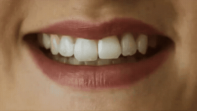 A Close Up Of A Woman 'S Mouth With Red Lips And White Teeth GIF