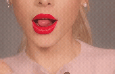 A Close Up Of A Woman 'S Mouth With Red Lipstick And Her Tongue Sticking Out GIF
