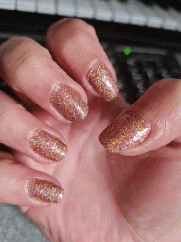 A Close Up Of A Woman 'S Nails With A Green Light On The Keyboard In The Background GIF