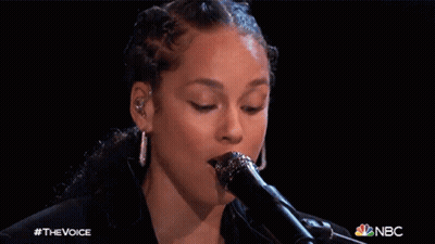A Close Up Of A Woman Singing Into A Microphone With The Nbc Logo In The Corner GIF