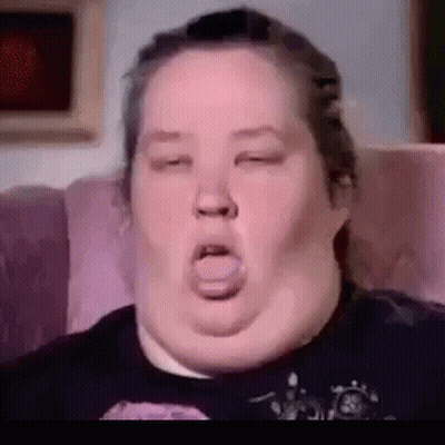 A Close Up Of A Woman Sitting On A Couch With Her Eyes Closed And Her Mouth Open . GIF