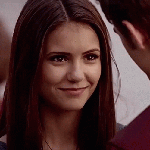 A Close Up Of A Woman Smiling At A Man While Looking At Him . GIF