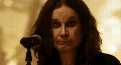 A Close Up Of A Woman Standing In Front Of A Microphone Making A Funny Face . GIF