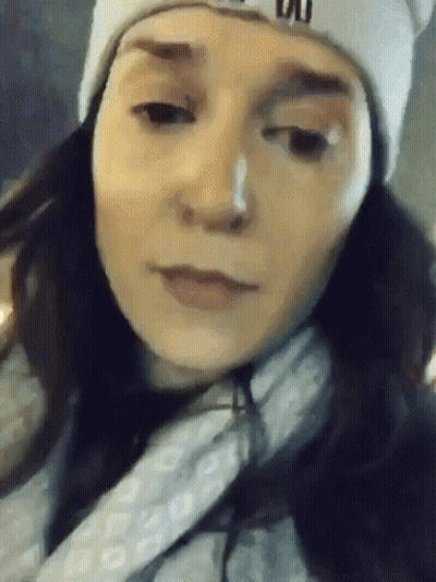 A Close Up Of A Woman Wearing A Beanie And A Scarf GIF