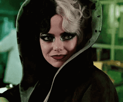 A Close Up Of A Woman Wearing A Black And White Wig And A Black Coat . GIF