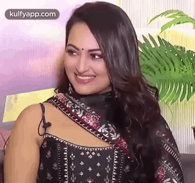 A Close Up Of A Woman Wearing A Black Dress And A Scarf Smiling . GIF