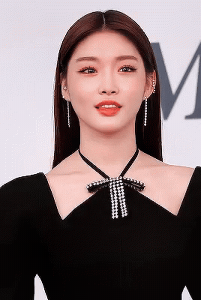 A Close Up Of A Woman Wearing A Black Dress With A Bow Around Her Neck . GIF