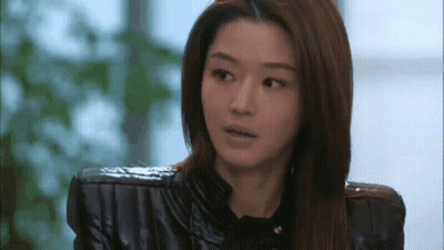 A Close Up Of A Woman Wearing A Black Leather Jacket And A Black Shirt . GIF