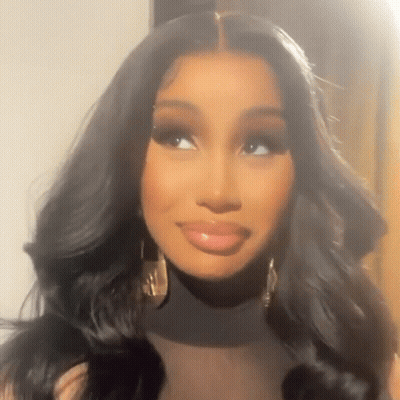 A Close Up Of A Woman Wearing A Black Turtleneck And Gold Earrings . GIF