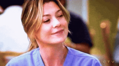 A Close Up Of A Woman Wearing A Blue Scrub Top And Smiling . GIF
