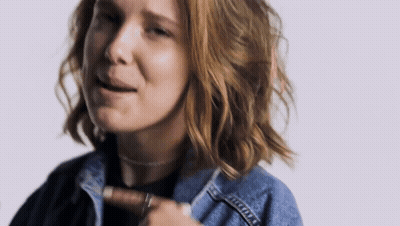 A Close Up Of A Woman Wearing A Denim Jacket And Choker . GIF