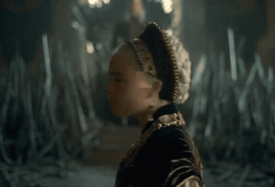 A Close Up Of A Woman Wearing A Gold Necklace And Earrings GIF