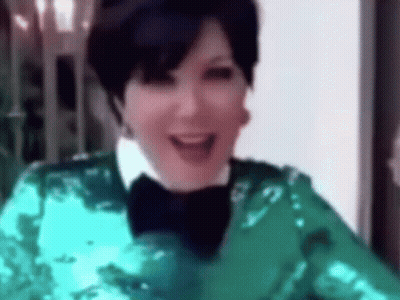 A Close Up Of A Woman Wearing A Green Jacket And A Bow Tie Smiling . GIF