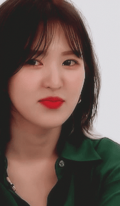 A Close Up Of A Woman Wearing A Green Shirt With Red Lipstick GIF