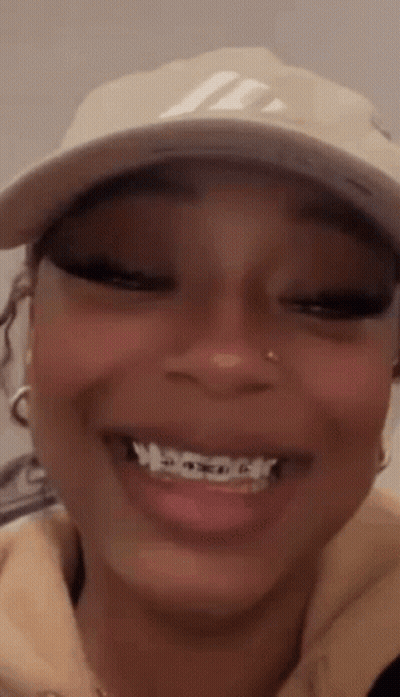 A Close Up Of A Woman Wearing A Hat And Smiling . GIF