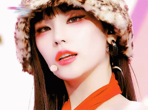 A Close Up Of A Woman Wearing A Leopard Print Hat And Scarf GIF