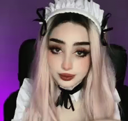 A Close Up Of A Woman Wearing A Maid Costume And A Hat . GIF