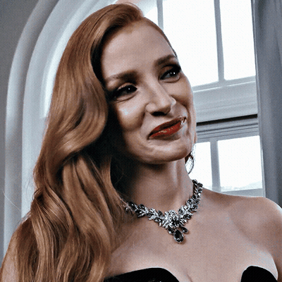 A Close Up Of A Woman Wearing A Necklace And A Black Dress GIF