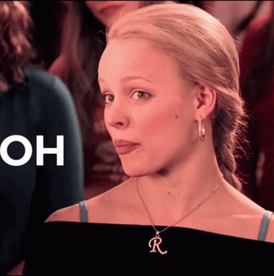 A Close Up Of A Woman Wearing A Necklace With The Letter R On It GIF