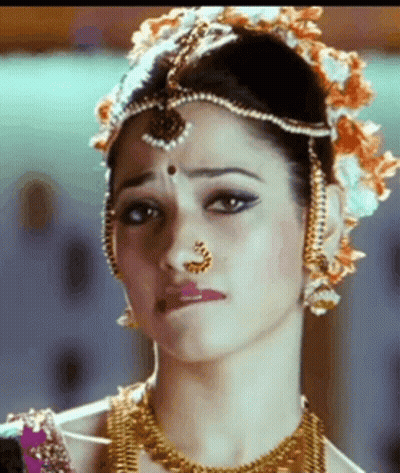 A Close Up Of A Woman Wearing A Nose Ring And A Headpiece . GIF