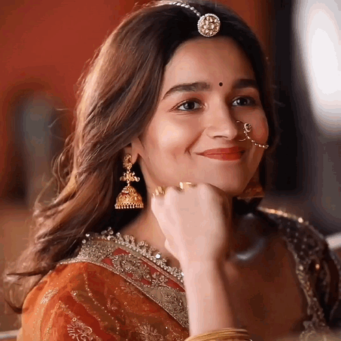 A Close Up Of A Woman Wearing A Nose Ring And Earrings GIF