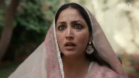 A Close Up Of A Woman Wearing A Pink Veil And Earrings . GIF