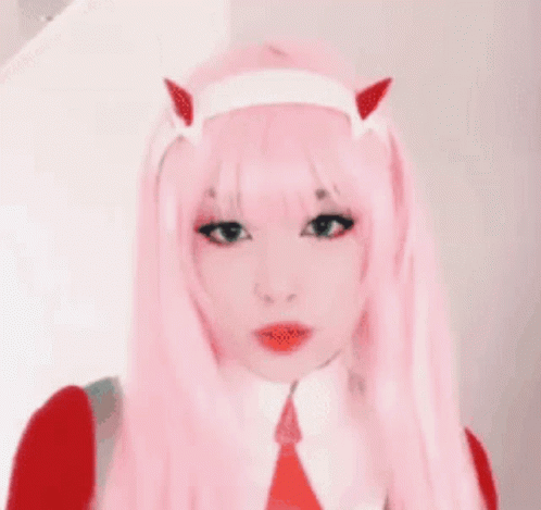 A Close Up Of A Woman Wearing A Pink Wig With Horns . GIF