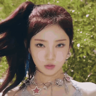 A Close Up Of A Woman Wearing A Ponytail And A Necklace With A Star On It . GIF