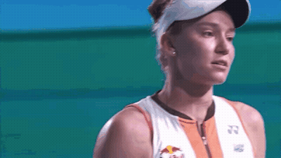 A Close Up Of A Woman Wearing A Red Bull Shirt And Visor GIF
