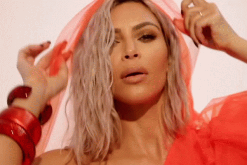 A Close Up Of A Woman Wearing A Red Dress And A Red Scarf Around Her Head . GIF