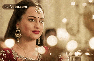 A Close Up Of A Woman Wearing A Red Dress And Jewelry . GIF